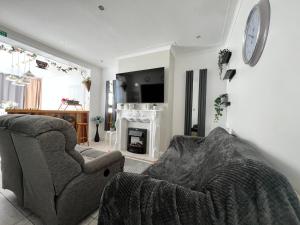 sala de estar con sofá, silla y chimenea en Cosy Family Get-Away 4 Bedrooms 7 Beds 2 Bathrooms, en Blackpool