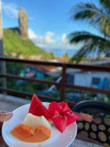 um prato de fruta numa mesa com vista para o oceano em Pousada Aratu em Fernando de Noronha