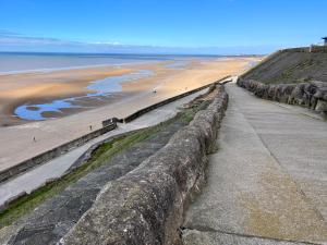 a stone wall next to a beach and the ocean at Cosy Family Get-Away 4 Bedrooms 7 Beds 2 Bathrooms in Blackpool