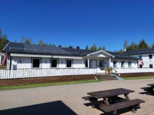 ein Gebäude mit zwei Picknicktischen davor in der Unterkunft Badeland Gjestegård in Raufoss