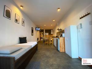 a room with a bed and a refrigerator and a kitchen at Beatriz Apartamentos - Monoambientes in General Pico