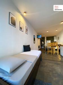 een kamer met 2 bedden en een keuken met een tafel bij Beatriz Apartamentos - Monoambientes in General Pico