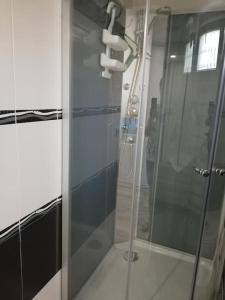 La salle de bains est pourvue d'une douche avec une porte en verre. dans l'établissement Chez Bernadette, à Le Fenouiller