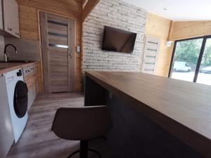 a kitchen with a large wooden counter with a chair at Domki letniskowe Leśny Chillout in Solina