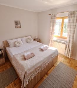 um quarto com uma cama com duas almofadas em Villa Ella Tvrdos em Trebinje