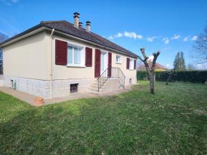 een wit huis met rode luiken op een tuin bij Le gîte du peintre in Entrains-sur-Nohain