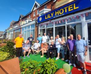 a group of people posing for a picture in front of a hotel at Lily Hotel in Blackpool