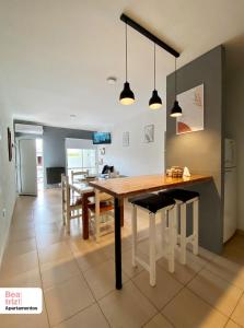 a kitchen and dining room with a wooden table and chairs at Beatriz Apartamentos - Dos Ambientes in General Pico