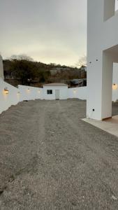 an empty driveway in front of a white building at Departamento isla central 2 in Mazatlán
