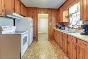uma cozinha com armários de madeira e um frigorífico branco em Cozy and Convenient Macon Home about 3 Mi to Town! em Macon