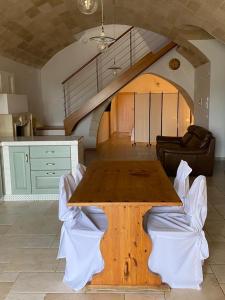 een keuken met een houten tafel en een woonkamer bij La Luna nei Sassi in Matera