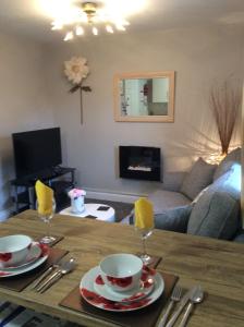 uma sala de estar com uma mesa com dois copos em Lesbury Lodge - (a 'bijou residence') with hot tub em Alnwick