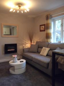 uma sala de estar com um sofá e uma mesa em Lesbury Lodge - (a 'bijou residence') with hot tub em Alnwick