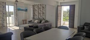 a living room with a couch and a table and chairs at Kiti Village Villa Larnaca, salt-water pool, 5 bedrooms in Kiti