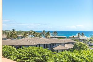 un balcón con vistas a las casas y al océano. en Kauai Makanui by Coldwell Banker Island Vacations, en Koloa