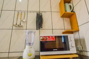 a blender sitting on a counter next to a microwave at Résidence Chic & Luxueux MD & NG à Bafoussam in Bafoussam