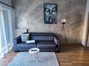 a living room with a blue couch and a mask at Ferienwohnung Susanna in Friedrichshafen