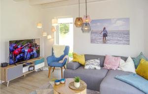 a living room with a couch and a tv at Lovely Home In Büsum Nordsee Ressort in Büsum