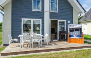 a deck with a white table and chairs on a house at Lovely Home In Büsum Nordsee Ressort in Büsum