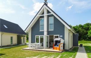 a house with a roof with a table and chairs at Lovely Home In Büsum Nordsee Ressort in Büsum