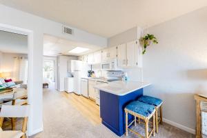 a kitchen with white appliances and a blue island at Sea Mark 208 in Ocean City