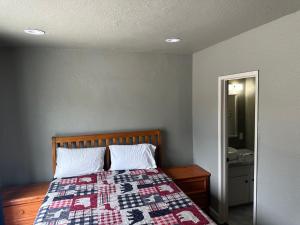 una camera con un letto con una trapunta sopra di Mountain Trail Lodge and Vacation Rentals a Oakhurst