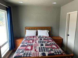 1 dormitorio con 1 cama con edredón en Mountain Trail Lodge and Vacation Rentals, en Oakhurst