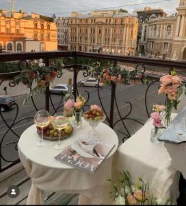 een tafel met wijnglazen en fruit op een balkon bij Ekaterina Apartments - Odessa in Odessa