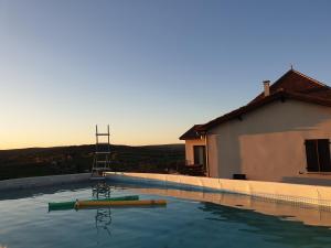 a swimming pool in front of a building at Villa avec magnifique point de vue 160 m2 10 personnes in Blars