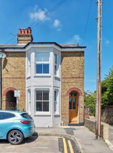 a brick house with a car parked in front of it at House on Beaconsfield spacious seaside home perfect for relaxing with friends or family in Deal