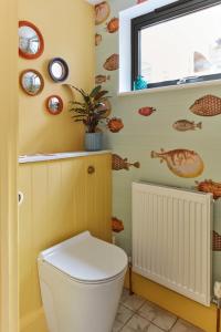 a bathroom with a white toilet and a window at House on Beaconsfield spacious seaside home perfect for relaxing with friends or family in Deal