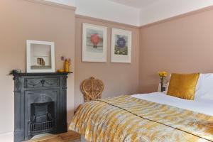 a bedroom with a bed and a fireplace at House on Beaconsfield spacious seaside home perfect for relaxing with friends or family in Deal