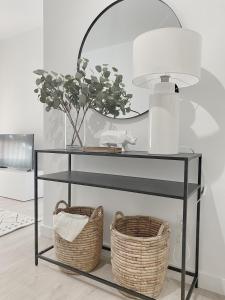 a black console table with two baskets and a lamp at Smart Stay Córdoba in Córdoba