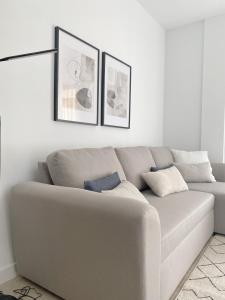 a couch in a living room with two pictures on the wall at Smart Stay Córdoba in Córdoba