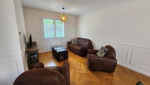 een woonkamer met 2 stoelen en een bank bij Le gîte du peintre in Entrains-sur-Nohain