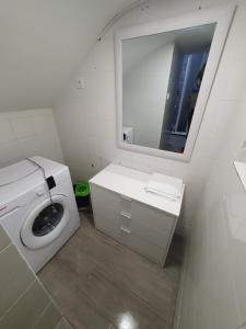 a bathroom with a washing machine and a mirror at Melania House in Candeleda