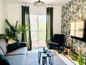 a living room with a couch and a table at LE PRADO - Spacieux studio tout confort sur les hauteurs de Grasse in Grasse
