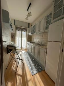 a kitchen with a white refrigerator and a table and chairs at Demy house in Passoscuro