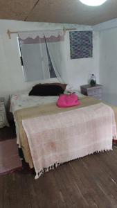 Dormitorio con cama con almohada rosa en Loft verocay, en Paysandú