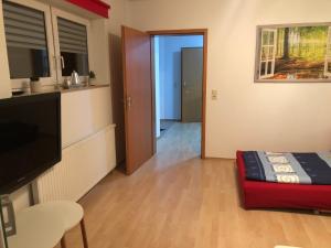 a living room with a bed and a door to a kitchen at Ferienwohnung TOBI in Bad Dürrheim