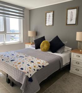 a bedroom with a bed with a yellow pillow on it at Apart Center Temuco in Temuco