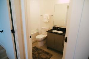 a bathroom with a toilet and a sink and a mirror at NEW Stylish 2BR Condo with Views in North End in Halifax