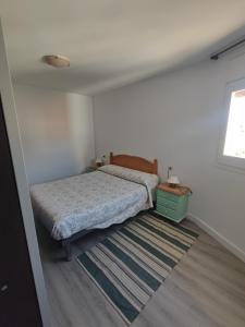 a small bedroom with a bed and a rug at L'Olivar in Port de la Selva