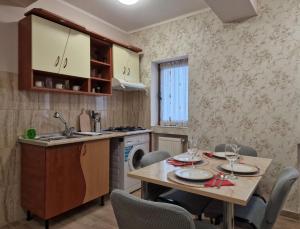 une cuisine avec une table et des chaises et une cuisine avec un évier dans l'établissement Laroka House Beautiful Apartment Universitate Center, à Bucarest