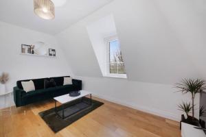 ビショップス・ストートフォードにあるRoomy One bed loft apartmentの緑のソファとテーブルのあるリビングルーム +1枚の写真