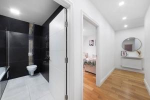 ビショップス・ストートフォードにあるRoomy One bed loft apartmentのバスルーム(シャワー、トイレ付)、ベッドルーム1室が備わります。
