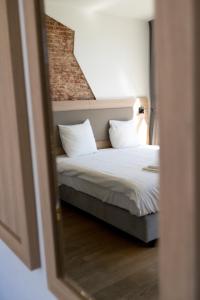 a bedroom with a bed with white sheets and pillows at Plantage Hortus Apartments in Amsterdam