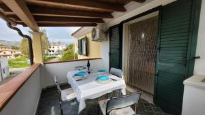 un tavolo e sedie sul balcone di una casa di Rossy house Orosei a Cala Liberotto