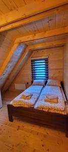 a bedroom with a bed in a wooden attic at Apartmani Prica in Crni Vrh