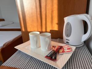 una mesa con dos tazas y una cafetera en Sobe Providenca Međugorje, en Međugorje